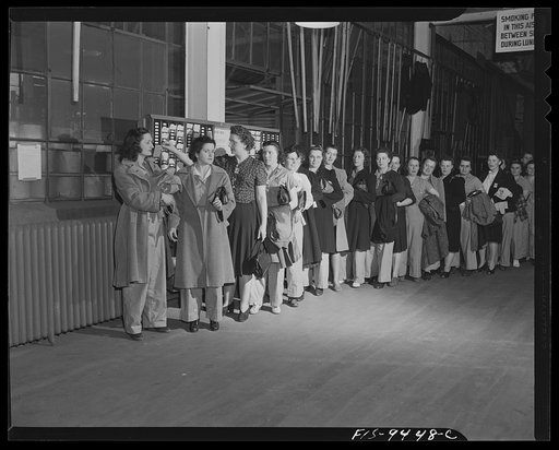 Untitled photo, possibly related to: De Soto bomber plant, Detroit, Michigan. Women war workers wearing slacks check out at end of a shift