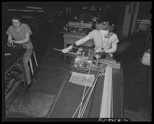 De Soto bomber plant, Detroit, Michigan. Woman worker producing simple curved form on magnesium conduit