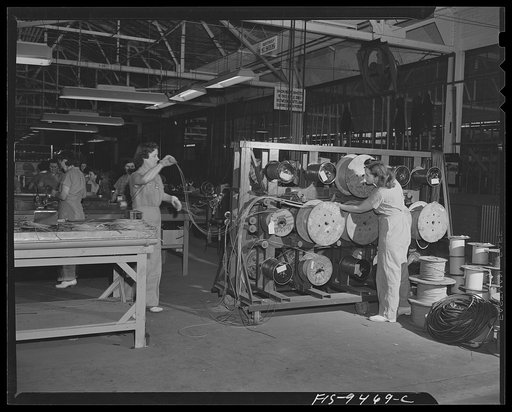 De Soto bomber plant. Detroit, Michigan. Woman worker and drums of various types of wire that are used for electrical connections throughout the bomber