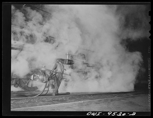 Tulsa, Oklahoma. Cleaning an engine with a steam pressure gun in the Frisco railroad yards at night