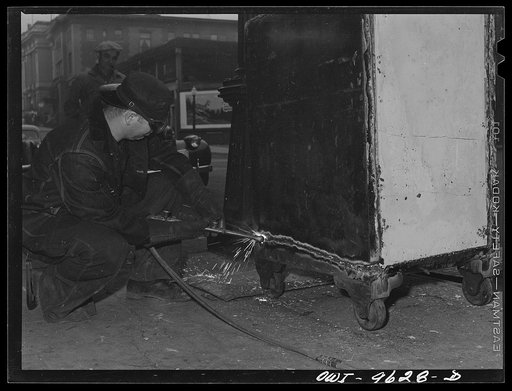Butte, Montana. Welder cutting up a safe for the scrap salvage campaign