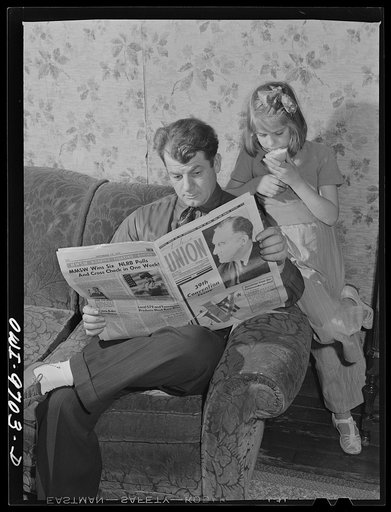Butte, Montana. Victor Rauh and one of his children reading a newspaper