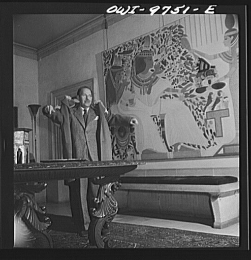 Washington, D.C. The Egyptian Legation on Massachusetts Avenue. Minister Hassan getting into his coat in the entrance hall of the Legation