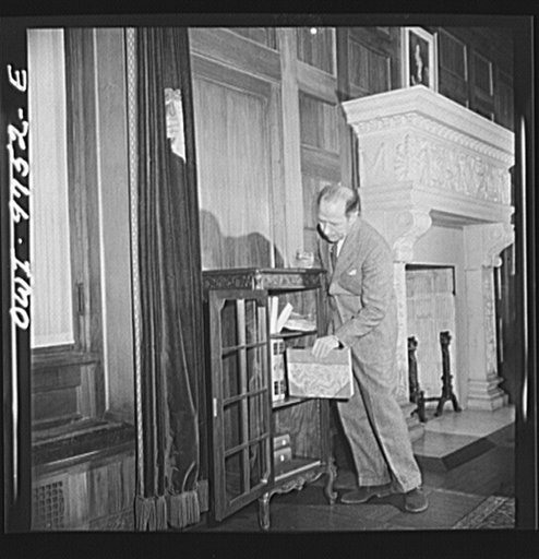 Washington, D.C. The Egyptian Legation on Massachusetts Avenue. Minister Hassan getting a book from his office shelves
