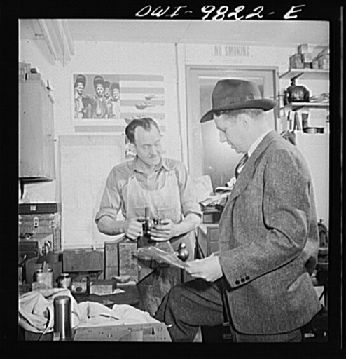 Passaic, New Jersey. Factory owner Carlson organized home machine shops for defense work. Carlson examining blueprints