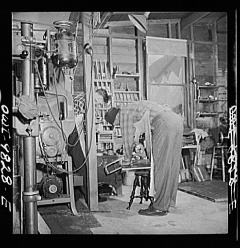 Passaic, New Jersey. Factory owner Carlson organized home machine shops for defense work. Helpers of a home machine shop owner. The piano stool serves as a horse
