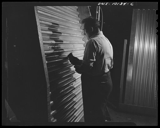 De Soto bomber plant. Detroit, Michigan. Worker bucking rivets on the corrugated surface of the inside center section