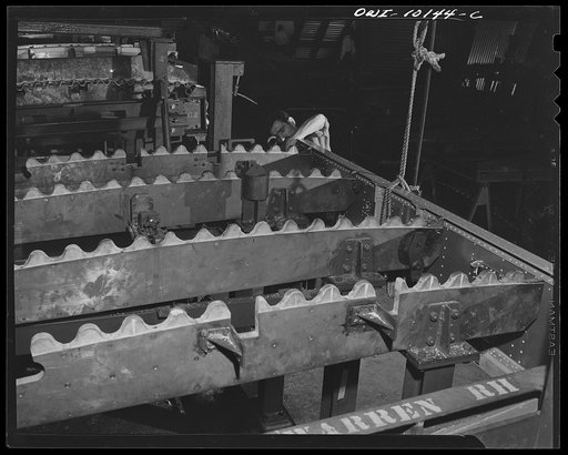 De Soto bomber plant. Detroit, Michigan. Loading a spar chord in a fixture. The spar cord is hanging on the end of the rope