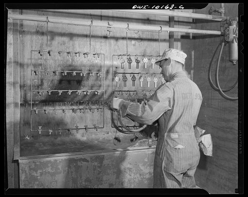 De Soto bomber plant, Detroit, Michigan. Spraying paint on the small parts in a paint booth