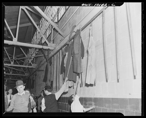 De Soto bomber plant, Detroit, Michigan. Worker's coats on racks lining the plant walls