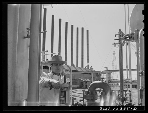 Gasoline plant employee operating a valve on a fractionating tower at the Phillips gasoline plant