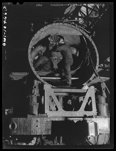 Untitled photo, possibly related to: Chicago, Illinois. In the roundhouse at an Illinois Central Railroad yard. This former switching engine is being rebuilt for use on the road