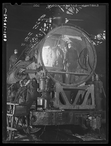 Chicago, Illinois. In the roundhouse at an Illinois Central Railroad yard. This former switching engine is being rebuilt for use on the road