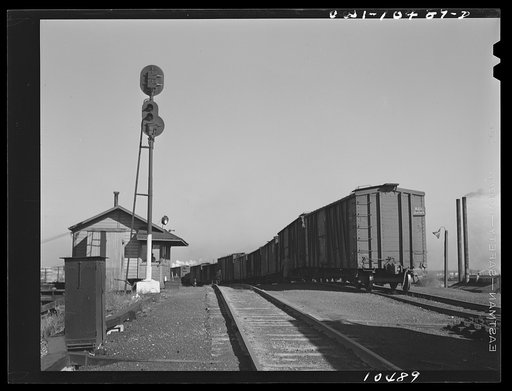 Untitled photo, possibly related to: Chicago, Illinois. Cars coming over the south hump at an Illinois Central Railroad yard. Cars are checked by an engine foreman in the building on the right and weighed as they pass by a weighmaster in the building on the right