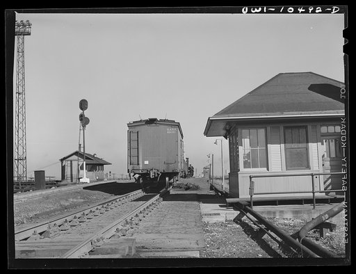 Chicago, Illinois. Cars coming over the south hump at an Illinois Central Railroad yard. Cars are checked by an engine foreman in the building on the right and weighed as they pass by a weighmaster in the building on the right