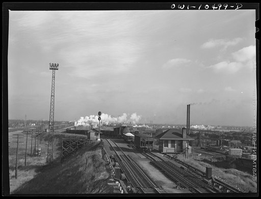 Untitled photo, possibly related to: Chicago, Illinois. Cars coming over the south hump at an Illinois Central Railroad yard. Cars are checked by an engine foreman in the building on the right and weighed as they pass by a weighmaster in the building on the right
