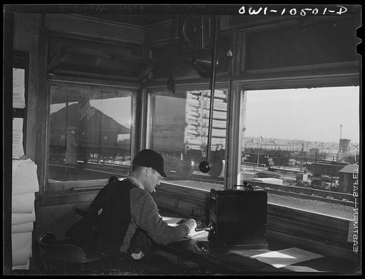 Chicago, Illinois. Engine foreman checking cars as they go over the hump at an Illinois Central Railroad yard