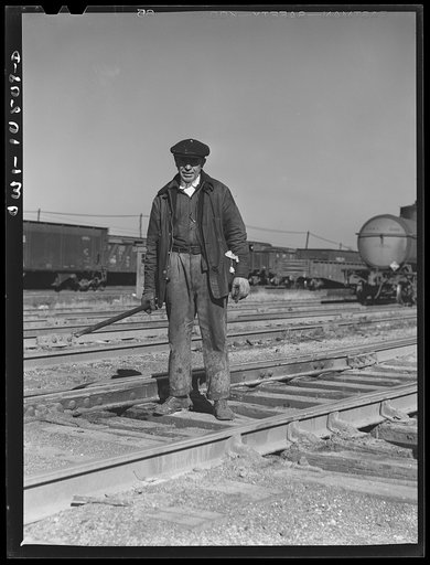Chicago, Illinois. One of the yard gang who was cleaning out switches at an Illinois Central Railroad yard