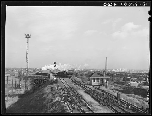 Untitled photo, possibly related to: Chicago, Illinois. Cars coming over the south hump at an Illinois Central Railroad yard. Cars are checked by an engine foreman in the building on the right and weighed as they pass by a weighmaster in the building on the right