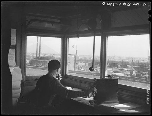 Chicago, Illinois. The engine foreman controls the cars coming over the hump at an Illinois Central Railroad yard and checks them against his list