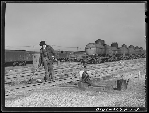 Untitled photo, possibly related to: Chicago, Illinois. One of the yard gang cleaning out switches at an Illinois Central Railroad yard