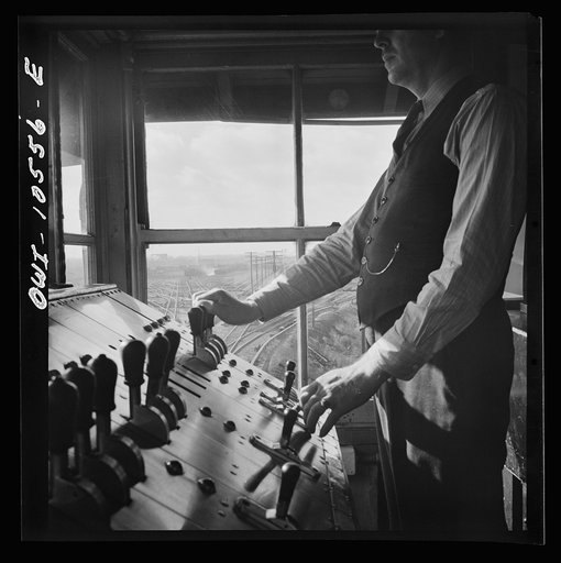 Untitled photo, possibly related to: Chicago, Illinois. A retarder operator at the south hump at an Illinois Central Railroad yard. From his control board he operates all the retarders and switches on his track