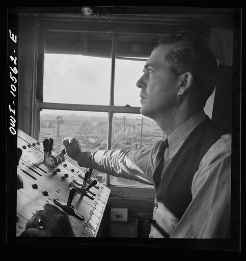 Chicago, Illinois. A retarder operator at the south hump at an Illinois Central Railroad yard. From his control board he operates all the retarders and switches on his track