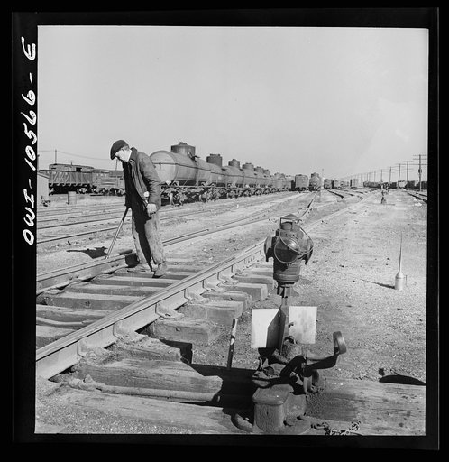 Chicago, Illinois. One of the yard gang cleaning out switches at an Illinois Central Railroad yard