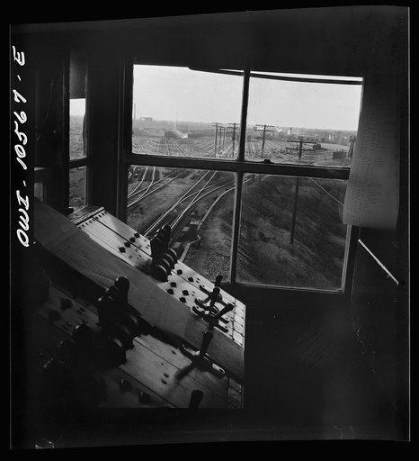 Untitled photo, possibly related to: Chicago, Illinois. A retarder operator at the south hump at an Illinois Central Railroad yard. From his control board he operates all the retarders and switches on his track