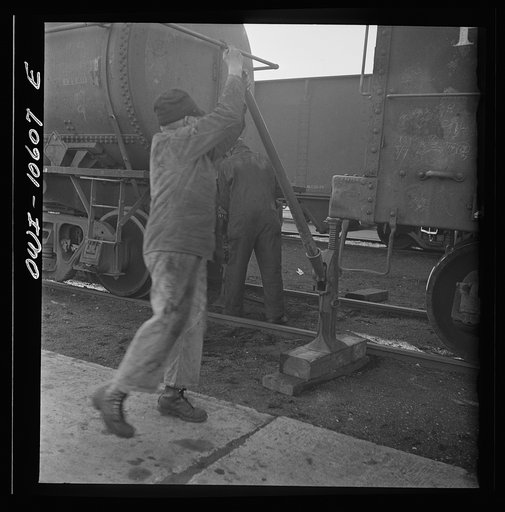 Untitled photo, possibly related to: Chicago, Illinois. Jacking up a car on the repair tracks at an Illinois Central Railroad yard