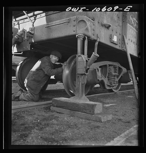 Untitled photo, possibly related to: Chicago, Illinois. Jacking up a car on the repair tracks at an Illinois Central Railroad yard