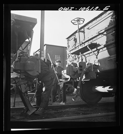 Chicago, Illinois. Jacking up a car on the repair tracks at an Illinois Central Railroad yard