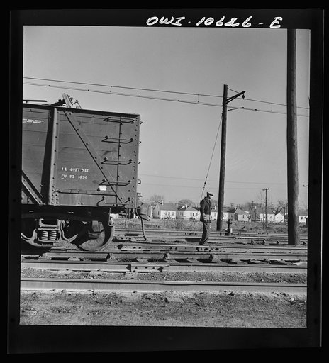 Chicago, Illinois. Brakeman going on the late afternoon shift, waiting to hop an engine to take him to his place of work in the Illinois Central Railroad yard