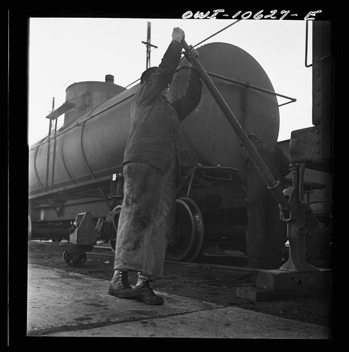 Untitled photo, possibly related to: Chicago, Illinois. Jacking up a car on the repair tracks at an Illinois Central Railroad yard