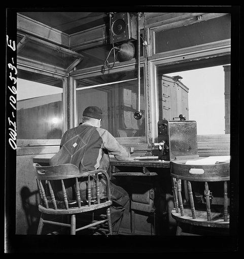 Untitled photo, possibly related to: Chicago, Illinois. As each car goes by his window at an Illinois Central Railroad yard, the engine foreman checks it against his switch list