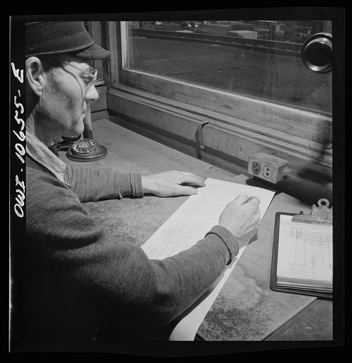 Chicago, Illinois. As each car goes by his window at an Illinois Central Railroad yard, the engine foreman checks it against his switch list