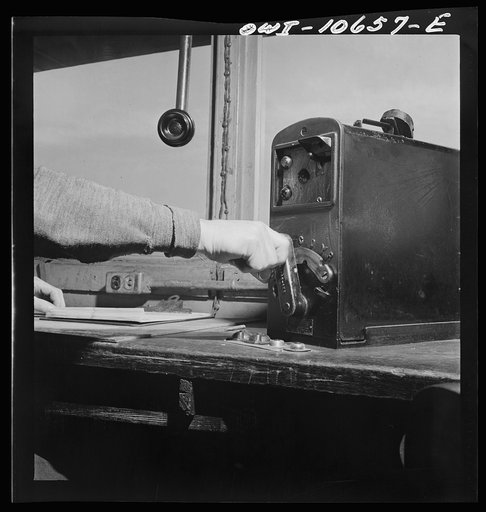 Chicago, Illinois. By means of light signals along the track, the engine foreman in his office gives directions to the engineer pushing a train over the hump at an Illinois Central Railroad yard