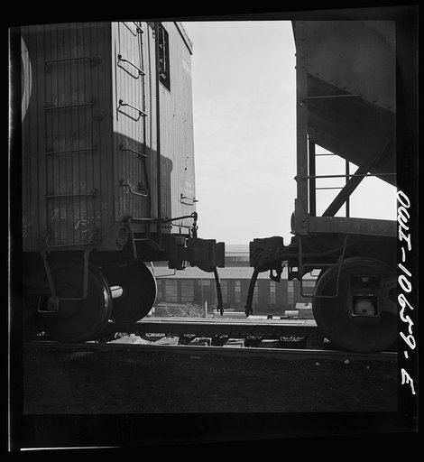 Chicago, Illinois. Cars are uncoupled at the top of the hump and roll down by gravity at an Illinois Central Railroad yard to the classification yards