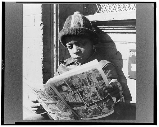 Washington, D.C. Negro youth reading a funny paper on a door step in the Southwest section