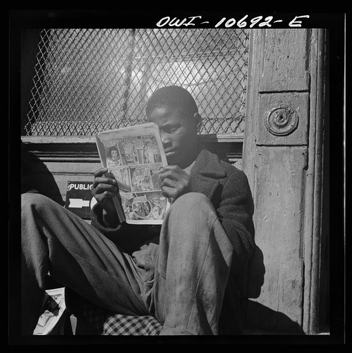Washington, D.C. Negro youth reading a funny paper on a door step in the Southwest section