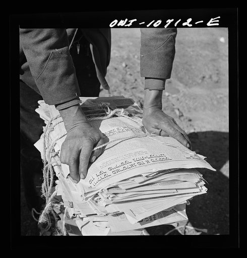 Washington, D.C. The hands of Mr. Venus Alsobrook, official salvage collector for the government, wrapping old newspapers he has gathered from different sections of the city