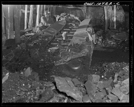 Untitled photo, possibly related to: Pittsburgh, Pennsylvania (vicinity). Montour no. 4 mine of the Pittsburgh Coal Company. After coal has been shot down by blasting, a mechanical loader is rolled into the "room". Electrically driven steel arms gather the coal and a conveyor belt moves it out to a 