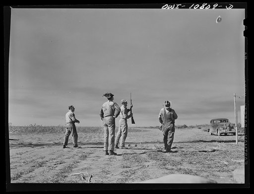 Moore County, Texas. Oil field roughnecks shooting at tin hats. While the rotary drill is "making hole" roughnecks have lots of spare time