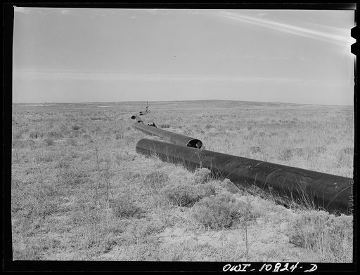 Untitled photo, possibly related to: Moore County, Texas. Pipe strung out awaiting trench digging crew