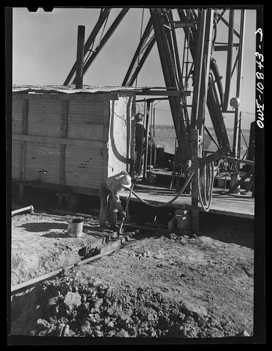 Untitled photo, possibly related to: Moore County, Texas. Driller at an oil well being drilled with a portable rotary drilling outfit