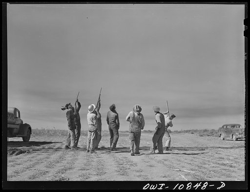 Moore County, Texas. Roughnecks shooting at tin hats while rotary drill is "making hole"