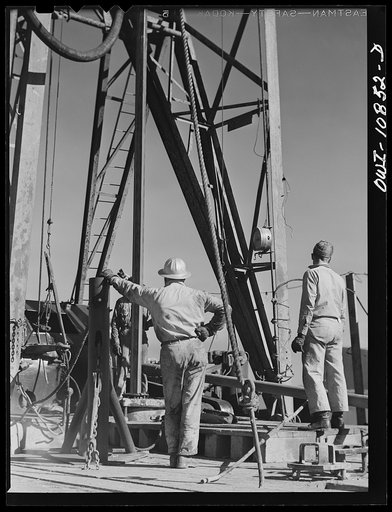 Moore County, Texas. Preparing to add length of drill pipe to rotary drill stem