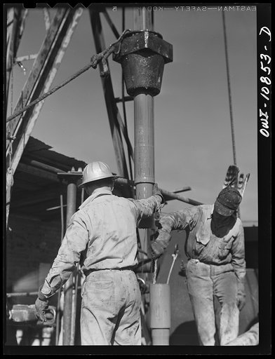 Untitled photo, possibly related to: Moore County, Texas. Preparing to add length of drill pipe to rotary drill stem