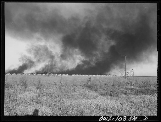 Moore County, Texas. Oil company production camp with smoke from carbon black plant in the background