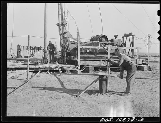 Untitled photo, possibly related to: Moore County, Texas. Adding length of pipe during rotary drilling operations